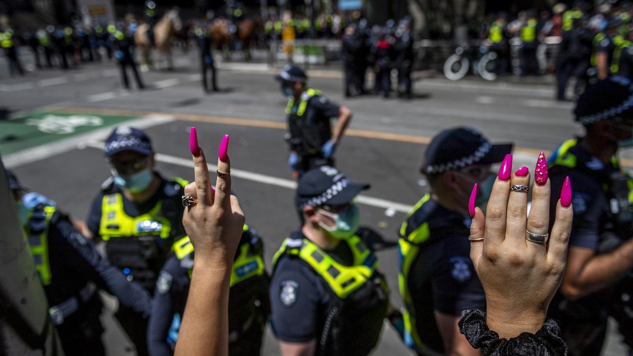 Protesters raise their hands and chant from inside the police kettle. Picture: Jake Nowakowski