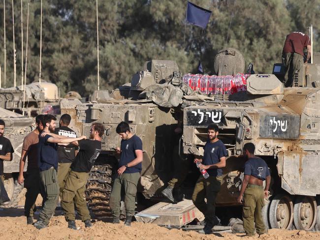 Israeli soldiers gather next to tanks at a position near Israel's border with the Gaza Strip. Picture: AFP
