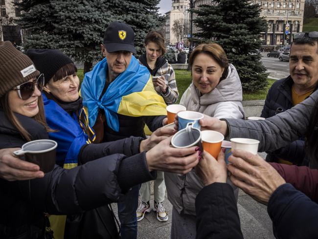 People drink sparking wine, waves flags and sing songs as they celebrate the liberation of part of the city of Kherson in Independence Squar. Picture: Getty Images