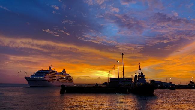 Golden hues hug the horizon as a cruise ship glides into the Port of Darwin. Picture: Ivanya Cunanan