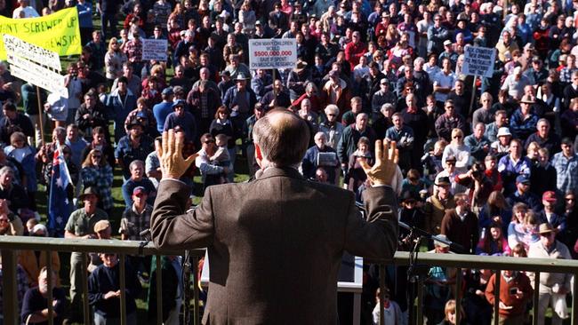 The famous image of Prime Minister John Howard wearing a bulletproof vest as he addresses farmers furious at his gun law reforms. Picture: Ray Strange