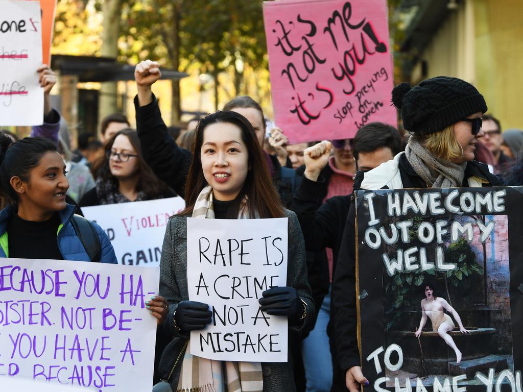 Protesters holding placards march along Swanston Street in Melbourne after Courtney Herron was killed. (AAP Image/James Ross)