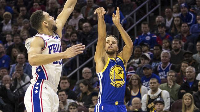 Golden State Warriors’ Stephen Curry, right, shoots a three-pointer past Philadelphia 76ers’ Ben Simmons. Picture: AP