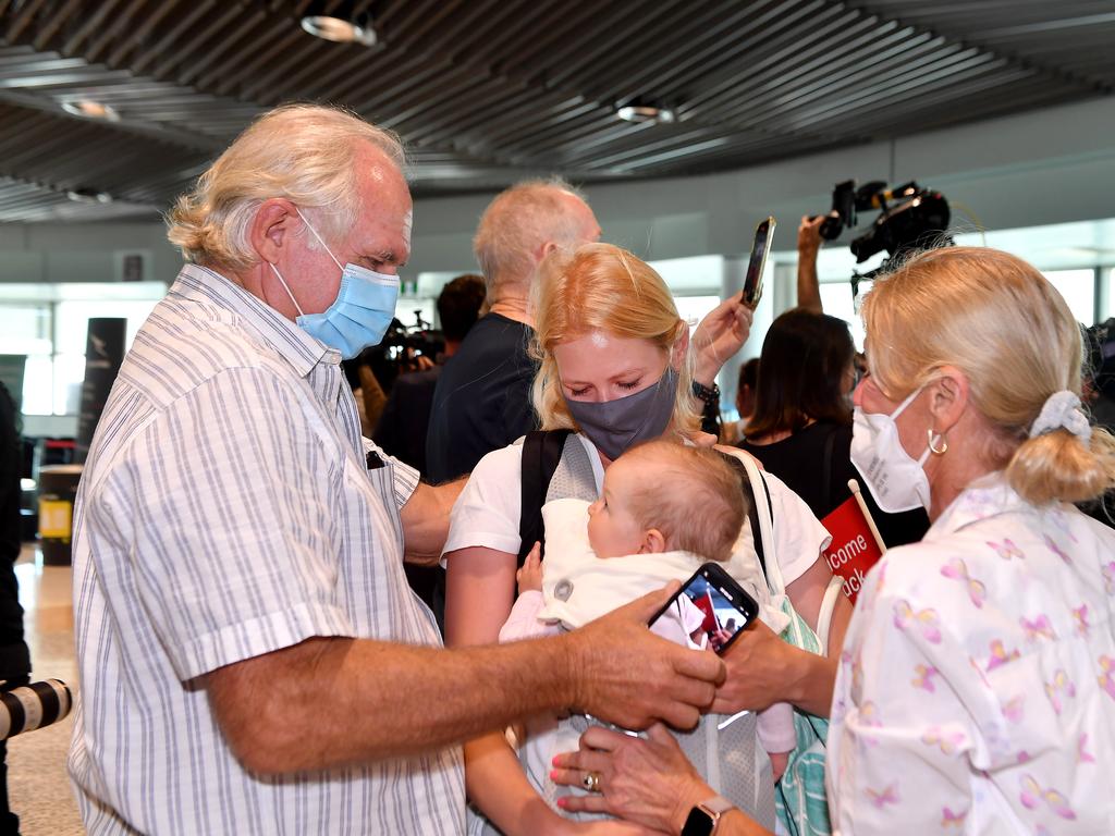 Rob Fyfe hugs daughter Alexandra Harg and granddaughter Hazel Harg with mum Maja after arriving on Qantas flight GF504 from Sydney to Brisbane. Picture: NCA NewsWire / John Gass