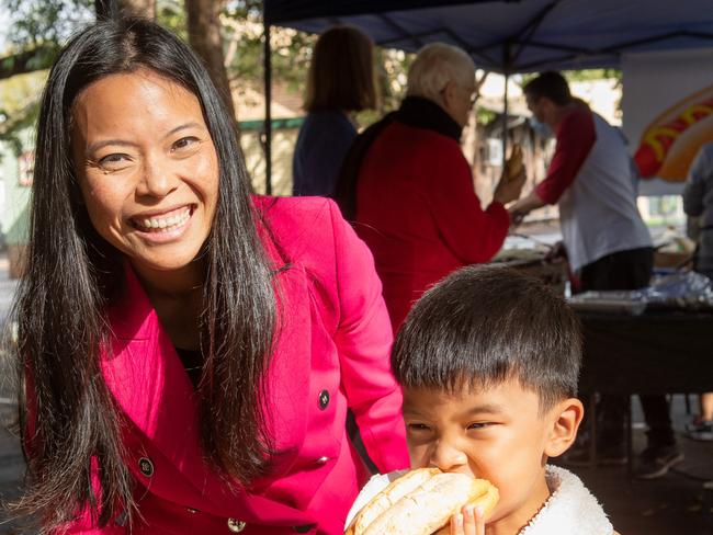 Sally Sitou and son Max enjoying a hot dog at the Strathfield North Primary school where they are campaigning in the seat of Reid. Picture: Brendan Read