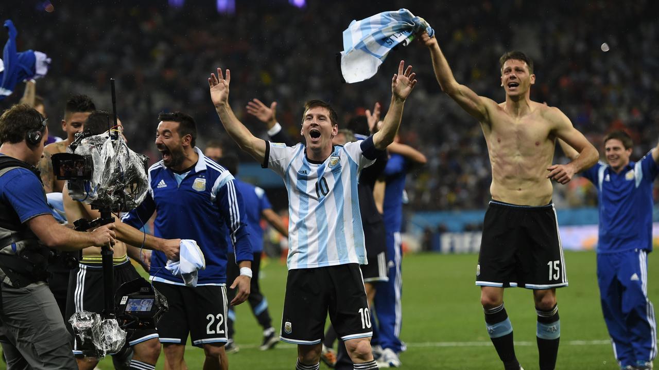 Argentina's forward and captain Lionel Messi celebrates with his teammates after winning their FIFA World Cup semi-final match against the Netherlands in a penalty shoot-out following extra time at The Corinthians Arena in Sao Paulo on July 9, 2014. AFP PHOTO / FABRICE COFFRINI