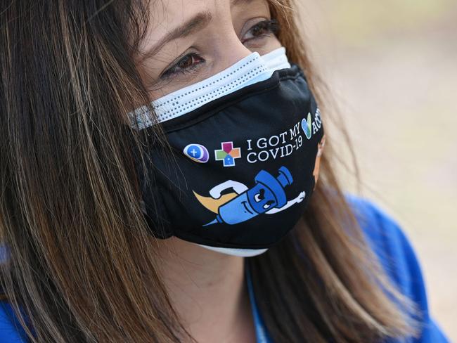 A healthcare workers wears a mask reading "I got my Covid-19 Vaccine" at a community vaccination event at QueensCare Health Center in a predominately Latino  neighborhood in Los Angeles, California, August 11, 2021. - All teachers in California will have to be vaccinated against Covid-19 or submit to weekly virus tests, Governor Gavin Newsom  announced on August 11, as authorities grapple with exploding infection rates. The number of people testing positive for the disease has surged in recent weeks, with the highly infectious Delta variant blamed for the bulk of new cases. (Photo by Robyn Beck / AFP)