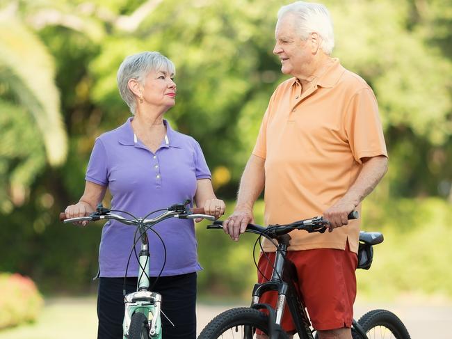 Active senior couple with bikes outdoors in the suburbs. Healthy baby boomers and seniors, generic retirement