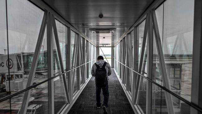 A passenger boards his flight at Tianhe Airport in Wuhan, China. Picture: AFP