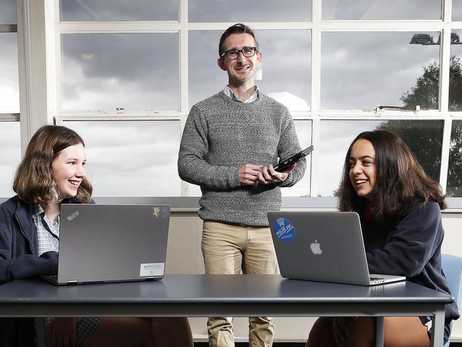 Taroona High School online learning co-ordinator Scott MacCrum with Grade 8 students Rayne Burgess-Stevens, 13, and Alisi Morris, 14. Picture: ZAK SIMMONDS