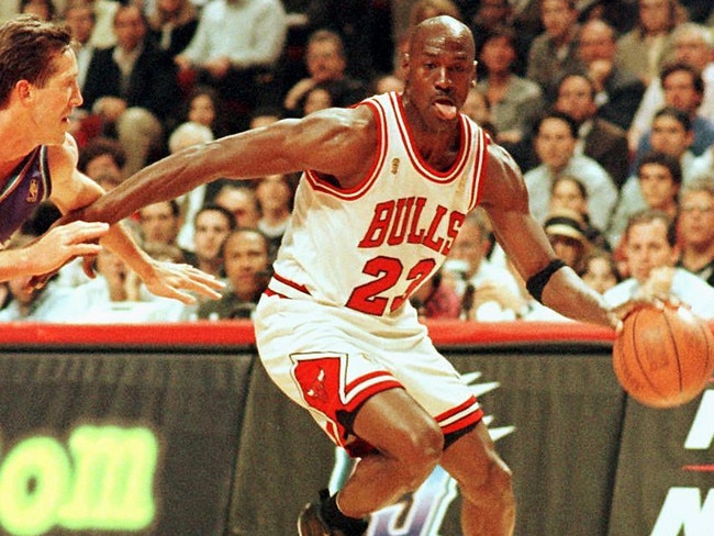 (FILES) In this file photo taken on June 4, 1997 former Chicago Bulls player Michael Jordan sticks out his tongue as he goes past Jeff Hornacek of the Utah Jazz during game two of the NBA Finals at the United Center in Chicago, IL. - Michael Jordan believes the Chicago Bulls 1990s NBA dynasty would have stayed together for at least one more season if team chiefs had backed coach Phil Jackson.  The retired legend made his comments in the last chapter of hit documentary "The Last Dance", saying he would have re-signed a one-year deal had management kept the team together, including Dennis Rodman, Scottie Pippen and Jackson. (Photo by VINCENT LAFORET / AFP)