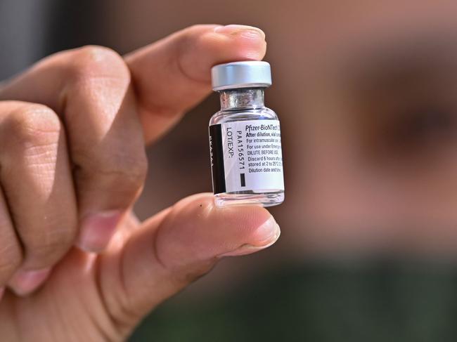 A health worker holds the Pfizer/BioNTech COVID-19 vaccine vial, at the Military College in Mexico City, on December 27, 2020. - Dozens of nurses and doctors felt they had regained "peace of mind" and strength to continue fighting the COVID-19 pandemic, after being vaccinated against the disease this Sunday in Mexico. (Photo by PEDRO PARDO / AFP)