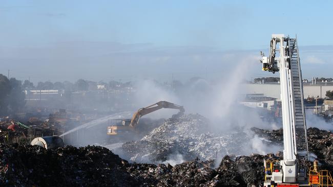 Firefighters at the smouldering Coolaroo recycling plant fire in 2017. Picture: David Crosling