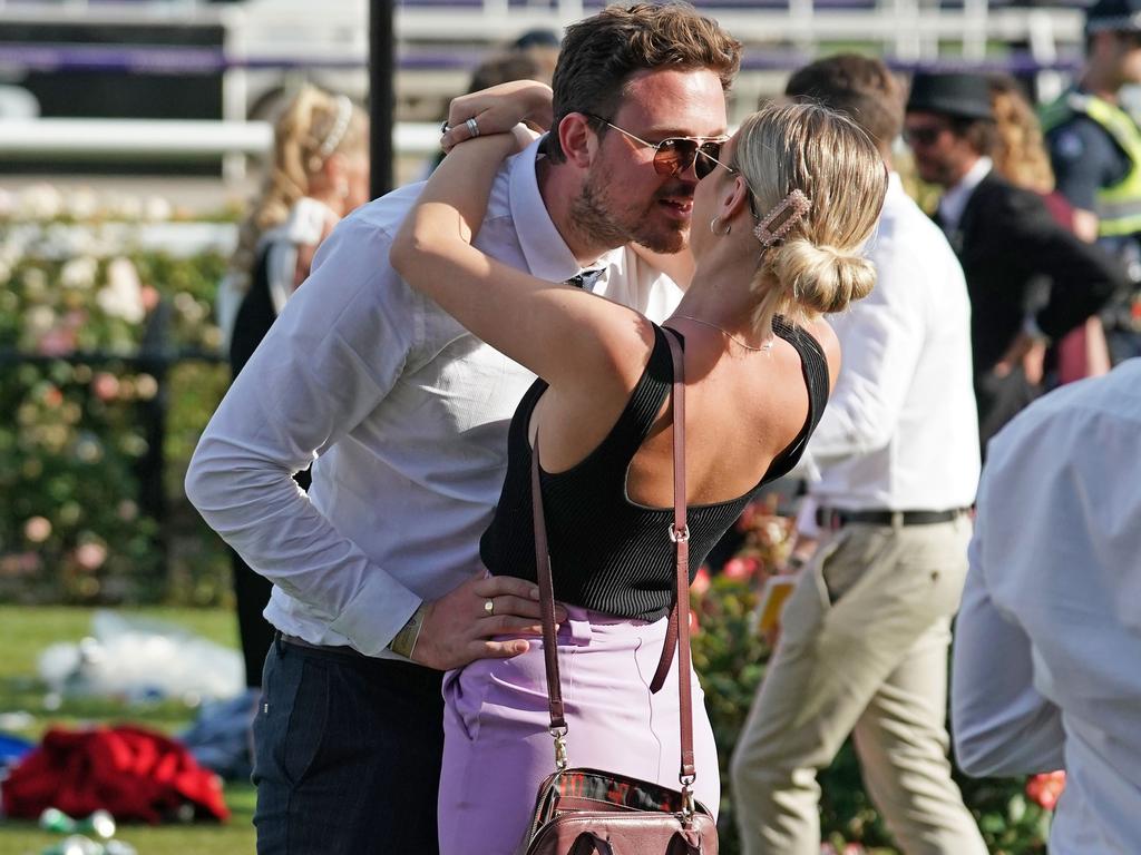 A couple enjoy a cheeky kiss at Flemington. Picture: AAP/Scott Barbour