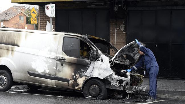 Police investigate a torched van outside a tobacconist shop on Belair Avenue in Glenroy. Picture: Andrew Henshaw