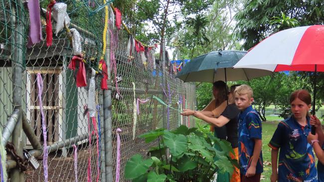 Students have written tributes on ribbons and attached them to the chook pen at Jingili Primary School after 10 of their chickens were killed. Picture: Bethany Griffiths