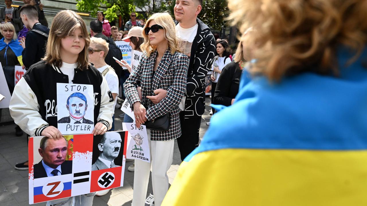 A child stands with a placard drawing resemblances between Russian President Vladimir Putin and Adolf Hitler during a protest in Budapest. Picture: Attila Kisbenedek/AFP