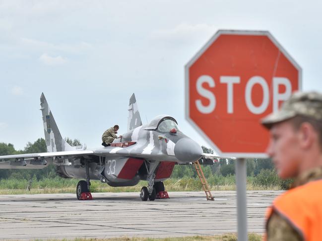 A technician prepares a Ukrainian MIG-29 fighter (NATO reporting name "Fulcrum") for its taking off prior to a practical flight during exercises at the Air Force military base in the small town of Vasylkiv, some 40km from Kiev on August 3, 2016.  / AFP PHOTO / SERGEI SUPINSKY