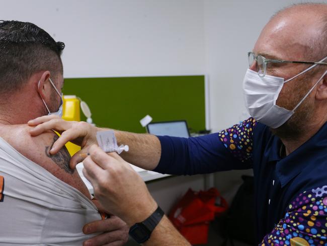 No vaccine hesitancy here. Clinical Nurse Tim Neate administers a Pfizer vaccination to a client at the Inner City Covid-19 Vaccine Hub in Sydney. Picture: Lisa Maree Williams/Getty Images