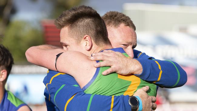 Ollie Graham celebrates with former A Grade coach Eric Kells after the Kookaburras’Grove coach Eric Kells and player #7 Oliver Graham with team celebrate their win against Golden Grove. Adelaide Footy League division three Grand Final Golden Grove v Flinders Park at Norwood Oval. Photographer Emma Brasier