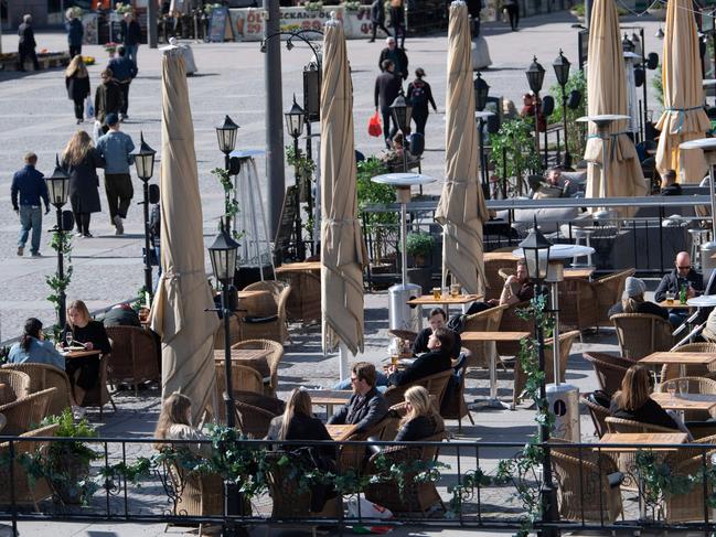 People sit at a cafe terrasse in central Stockholm, Sweden. Picture: AFP