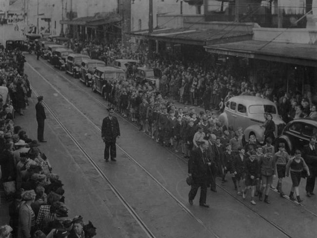 Children from Joan’s school follow the hearse during a funeral procession to Botany Cemetery.