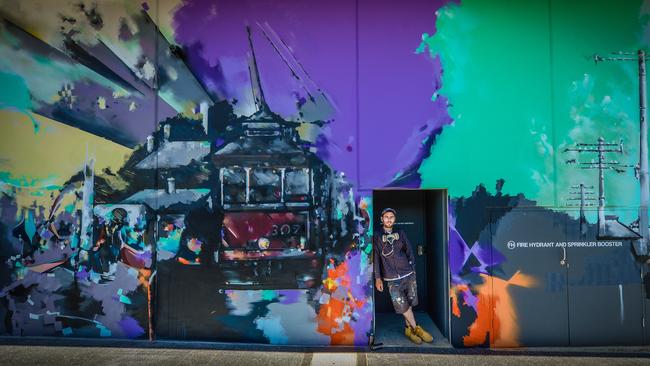 Artist Adam Poole-Mottishaw with his nearly finished art work on the new Palace Nova Prospect cinema. Picture: AAP/Roy VanDerVegt