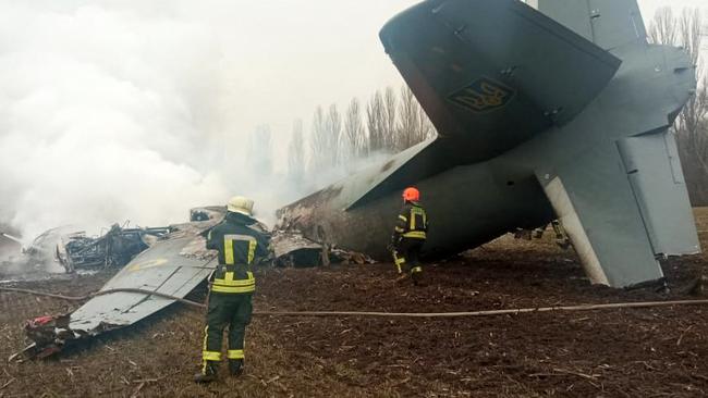 Emergencies personnel work at the crash site of a Ukrainian military plane south of Kyiv on February 24, 2022. (Photo by Handout / UKRAINE EMERGENCY MINISTRY PRESS SERVICE / AFP)