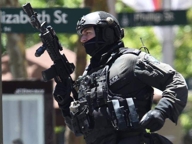 (FILES) This file photo taken on December 15, 2014 shows an armed policeman seen outside a cafe in the central business district of Sydney during a siege.  Police underestimated the threat posed by a self-styled Islamic cleric during a Sydney cafe siege and took too long to storm the building, an inquest found on May 24, 2017, but it absolved them of blame for two deaths. / AFP PHOTO / SAEED KHAN