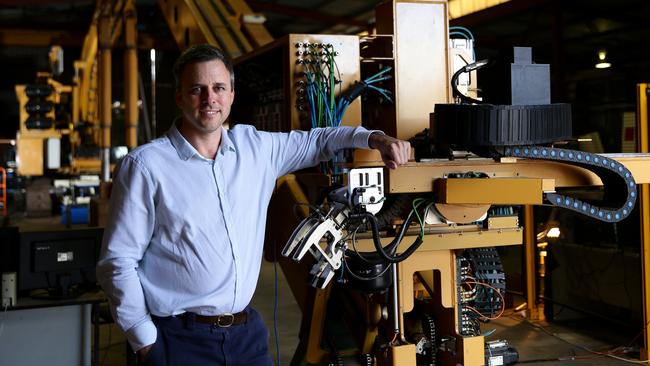 Mark Pivac in front of the prototype machine, a robotic bricklaying device being developed by Fastbrick Robotics, photographed in Walliston.