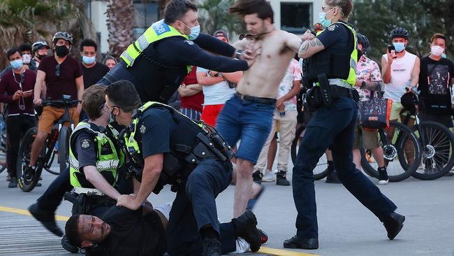 A man is arrested along St Kilda foreshore while not wearing a mask Picture: Ian Currie