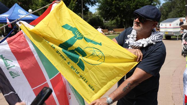 Al Yazbek holds a yellow flag resembling the Hezbollah flag, with a Ned Kelly-like figure brandishing a gun on it, at the pro-Palestine protest at Hyde Park in Sydney's CBD. Picture: NewsWire/Damian Shaw