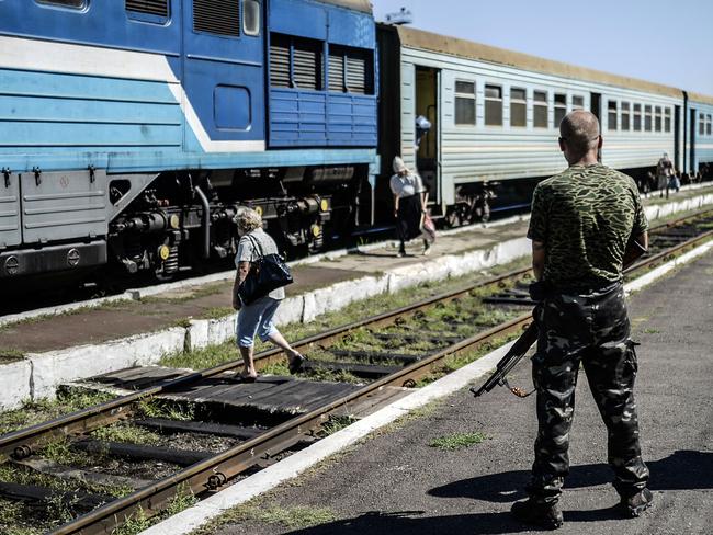 An armed separatist guard in front of wagons containing the remains of victims from the downed Malaysia Airlines Flight MH17. AFP PHOTO/ BULENT KILIC