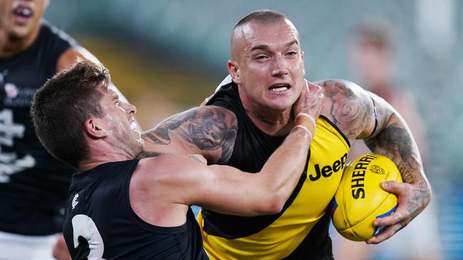 Dustin Martin of the Tigers fends off Marc Murphy of the Blues during the Round 1 AFL match between Richmond and Carlton at the MCG in Melbourne, Thursday, March 19, 2020. (AAP Image/Michael Dodge) NO ARCHIVING, EDITORIAL USE ONLY