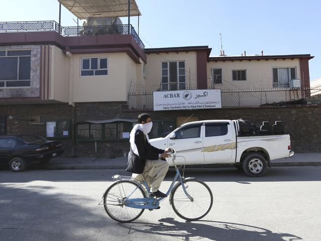 An Afghan man ride his bicycle in front of the office of the Agency Coordinating Body for Afghan Relief (ACBAR) in Kabul, Afghanistan, Sunday, Nov. 6, 2016. An Australian woman has been kidnapped from the Afghan capital Kabul by unknown gunmen. An official with the Kabul police chief's office, speaking on condition of anonymity in line with regulations, confirmed on Sunday that the woman was abducted the previous night and that she works for the Agency Coordinating Body for Afghan Relief or ACBAR. (AP Photo/Rahmat Gul)