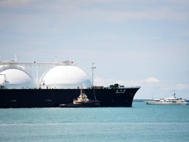 A massive cargo ship with natural gas dwarfs a yacht in the Darwin Harbour as it departs from the Ichthys LNG Project at its onshore gas liquefaction plant in Darwin on Friday morning.Picture: Justin Kennedy