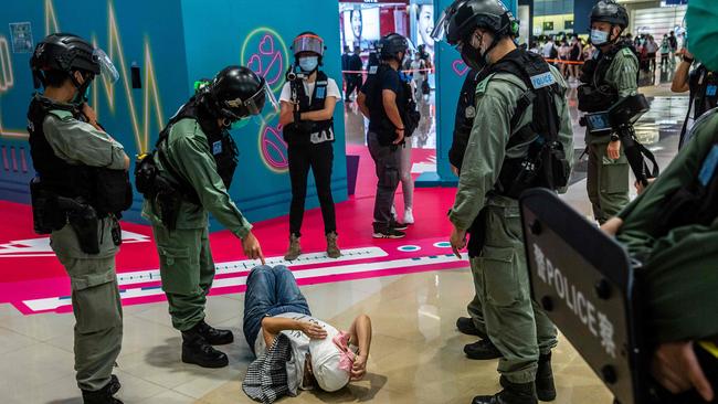 A riot police officer points at a woman protester in Hong Kong this month. Picture: AFP