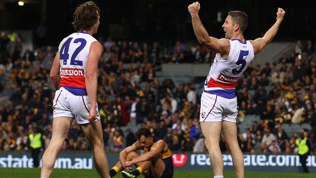 Veteran Bulldog Matthew Boyd celebrates on the siren while Eagle Dom Sheed slumps to the ground. Picture: Getty