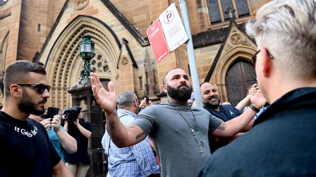 A man is moved-on by Police after he confronted protesters at the Cardinal George Pell service at St Mary's Cathedral in Sydney ahead of a requiem mass and private burial service.  Picture: NCA NewsWire / Jeremy Piper