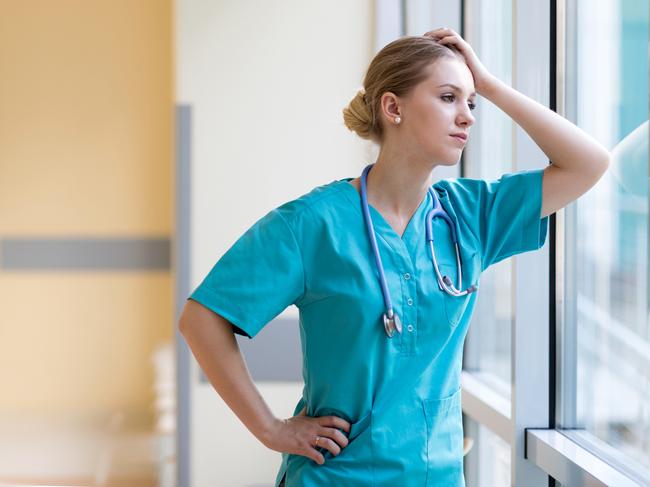 Tired female nurse in hospital corridor istock image