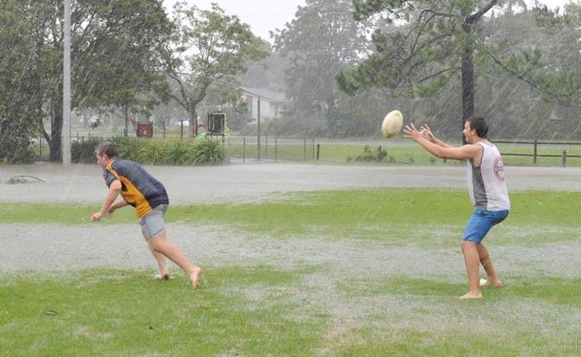 Bored with being stuck inside, Liam McIntyre and Andrew Mirkovic of Alstonville defied the storm to play a game of football at Geoff Watt Oval in Alstonville. Picture: Cathy Adams