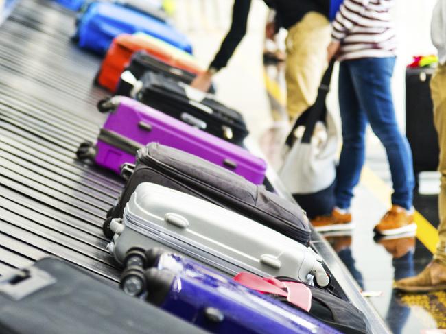 Luggages moving on airport conveyor belt.