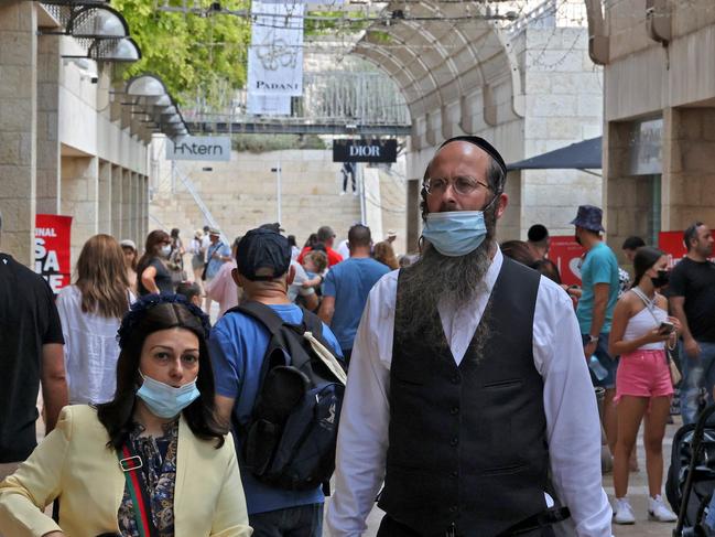 People wear masks against the coronavirus as they walk at a market in Jerusalem. Picture: AFP