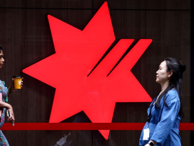Pedestrians walk past the logo of National Australia Bank, on display outside a branch in central Sydney on November 7, 2024. National Australia Bank released its full-year financial results for 2024 on November 7. (Photo by DAVID GRAY / AFP)