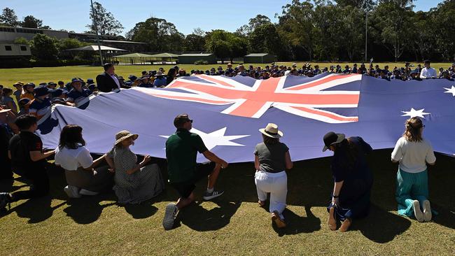 Students from Jindalee State School in Brisbane help the Speaker of the House of Representatives, the Hon Milton Dick MP, hold up the Australian Parliament House flag. Picture: Lyndon Mechielsen