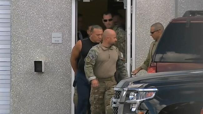 FBI agents escort Cesar Sayoc, in sleeveless shirt, in Miramar, Florida, on Friday. Authorities identified him on Friday as the Florida man who put pipe bombs in small manila envelopes, affixed six stamps and sent them to some of Donald Trump's most prominent critics. Picture: AP