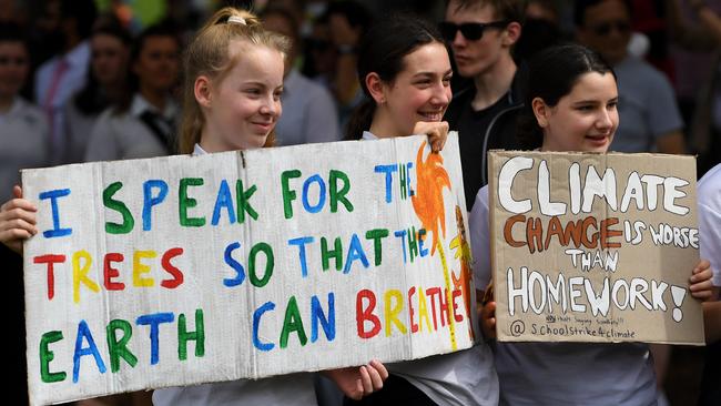 Students with handpainted signs at the rally. Picture: James Ross/AAP.