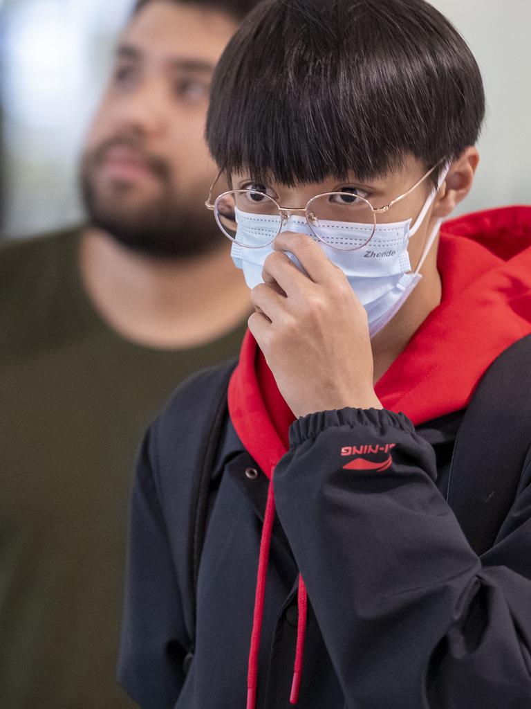 People wearing protective face masks to protect themselves from Coronavirus are seen at Brisbane International Airport. Picture: AAP Image/Glenn Hunt.