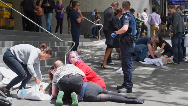 Paramedics and members of the public come to the aid of injured pedestrians. Picture: Tony Gough