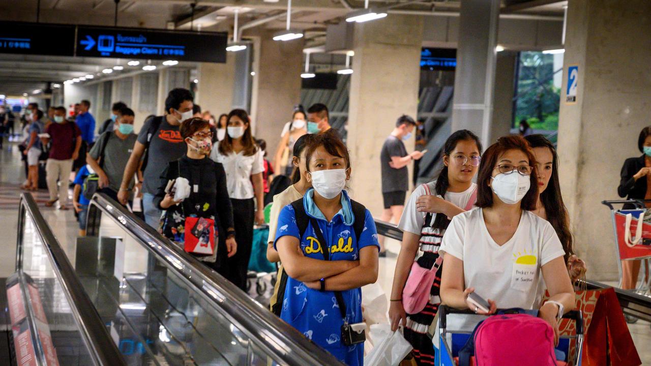 Passengers wearing protective face masks walk toward their departure gate at Suvarnabhumi International Airport in Bangkok on February 9. Picture: Mladen Antonov/AFP